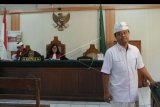 Mantan Ketua Kamar Dagang dan Industri (Kadin) Bali, Anak Agung Ngurah Alit Wiraputra (kanan) meninggalkan ruang sidang usai menjalani sidang dakwaan di Pengadilan Negeri Denpasar, Bali, Senin (17/6/2019). Ngurah Alit Wiraputra menjadi terdakwa terkait kasus dugaan penipuan pengurusan perizinan pelebaran kawasan Pelabuhan Pelindo, Benoa, Bali. ANTARA FOTO/Fikri Yusuf/nym.