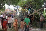 Sejumlah warga melihat mobil bus BL 7776 AA  setelah bertabrakan dengan mobil minibus dengan Nopol BK 1085 ZS  di Jalan Lintas Nasional Medan-Banda Aceh Desa Meunasah Leubok, Aceh Timur, Aceh, Senin (17/6/2019). Kecelakaan tersebut diduga akibat kelalaian salah satu pengemudi sehingga mengakibatkan enam orang meninggal dunia. (Antara Aceh/Syifa Yulinnas)