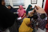 Warga antre mendapatkan layanan pemeriksaan kesehatan saat Bhakti Sosial Kesehatan di Klinik Abdihusada Utama, Surabaya, Jawa Timur, Senin (17/6/2019). Sekitar 1.000 orang yang kurang mampu mendapatkan layanan kesehatan gratis diantaranya operasi bibir sumbing, operasi katarak, khitan, pemeriksaan gigi dan pengobatan umum yang digelar oleh Polda Jawa Timur untuk menyambut HUT ke-73 Bhayangkara itu. Antara Jatim/Didik Suhartono/ZK