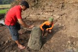  Anggota komunitas pemerhati budaya 'Damar Panuluh' membersihkan batu menyerupai Lingga di area struktur bangunan kuno di Desa Krecek, Kediri, Jawa Timur, Senin (17/6/2019). Struktur bangunan kuno seluas 10 meter x 10 meter di tengah sawah tersebut dilaporkan komunitas 'Damar Panuluh' ke Dinas Kebudayaan dan Pariwisata untuk diteliti lebih lanjut karena diduga merupakan bangunan candi. Antara Jatim/Prasetia Fauzani/zk