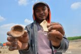 Warga menunjukan pecahan keramik dan gerabah di areal sawah bekas tambang galian C Dusun Kedaton, Desa Bulurejo, Kecamatan Diwek, Jombang, Jawa Timur, Selasa (18/6/2019). Batu bata kuno ditemukan pekerja saat melakukan penggalian tanah galian C di areal persawahan tersebut, selain itu juga ditemukan pecahan keramik serta gerabah. Antara Jatim/Syaiful Arif/zk.