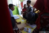 Warga mencari informasi lowongan pekerjaan saat bursa kerja di halaman Dinas Tenaga Kerja, Kediri, Jawa Timur, Rabu (19/6/2019). Pemerintah daerah setempat rutin menyelenggarakan bursa kerja empat kali dalam setahun dengan menggandeng puluhan perusahaan guna menekan angka pengangguran. Antara Jatim/Prasetia Fauzani/zk.