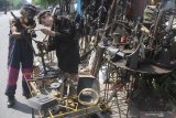 Seniman patung, Sumarsono (kiri) berkolaborasi dengan pematung asal Inggris, Michelle Laing (kanan) membuat patung dari besi bekas di Malang, Jawa Timur, Rabu(19/6/2019). Kolaborasi pematung Indonesia-Inggris tersebut merupakan salah satu upaya mensosialisasikan pemanfaatan besi bekas sebagai karya seni. Antara Jatim/Ari Bowo Sucipto/zk.