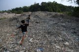 Sejumlah anak berlarian di tumpukan sampah plastik impor di Desa Bangun di Mojokerto, Jawa Timur, Rabu (20/6/2019). Berdasarkan data Lembaga Kajian Ekologi dan Konservasi Lahan Basah Ecoton bahwa masuknya sampah dengan merk dan lokasi jual di luar Indonesia, diduga akibat kebijakan Cina menghentikan impor sampah plastik dari sejumlah negara di Uni Eropa dan Amerika yang mengakibatkan sampah plastik beralih tujuan ke negara-negara di ASEAN. Indonesia diperkirakan menerima sedikitnya 300 kontainer yang sebagian besar mengangkut sampah plastik ke Jawa Timur setiap harinya. Antara Jatim/Zabur Karuru