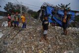 Sejumlah anak berada di tumpukan sampah plastik impor di Desa Bangun di Mojokerto, Jawa Timur, Rabu (20/6/2019). Berdasarkan data Lembaga Kajian Ekologi dan Konservasi Lahan Basah Ecoton bahwa masuknya sampah dengan merk dan lokasi jual di luar Indonesia, diduga akibat kebijakan Cina menghentikan impor sampah plastik dari sejumlah negara di Uni Eropa dan Amerika yang mengakibatkan sampah plastik beralih tujuan ke negara-negara di ASEAN. Indonesia diperkirakan menerima sedikitnya 300 kontainer yang sebagian besar mengangkut sampah plastik ke Jawa Timur setiap harinya.  Antara Jatim/Zabur Karuru
