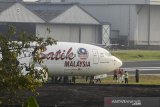 Petugas melakukan pemeriksaan pesawat Maskapai Malindo Air (Batik Malaysia) yang keluar dari landas pacu di Bandar Udara Internasional Husein Sastranegara, Bandung, Jawa Barat, Kamis (20/6/2019). Sebanyak 114 penumpang dan delapan kru pesawat berhasil dievakuasi dengan selamat dan aman setelah maskapai penerbangan bernomor OD-301 yang beroperasi dengan Boeing 737-800NG tujuan Bandung-Malaysia tersebut tergelincir keluar landas pacu Bandar Udara Internasional Husein Sastranegara saat berbelok sebelum lepas landas. ANTARA JABAR/Novrian Arbi/agr