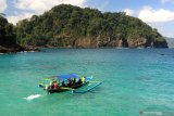 Wisatawan naik perahu di Pantai Teluk Hijau di Banyuwangi, Jawa Timur, Selasa (18/6/2019). Pantai berpasir putih dan masih alami yang dapat ditempuh menggunakan perahu nelayan sekitar 15 menit tersebut, merupakan salah satu wisata pantai unggulan di Banyuwangi. Antara Jatim/Budi Candra Setya/zk