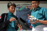 Siswa SMPN 4 Surabaya memperlihatkan cara kerja alat pemandu yang dipasang pada sepatu bagi penyandang tuna netra dalam pameran International Science and Invention di Denpasar, Bali, Sabtu (22/6/2019). Kegiatan yang memamerkan karya hasil penelitian tersebut diikuti 101 pelajar/mahasiswa se-Indonesia serta 46 pelajar/mahasiswa dari 10 negara. ANTARA FOTO/Nyoman Hendra Wibowo/nym