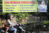 Pengendara sepeda motor melintas di depan spanduk larangan buang sampah sembarangan di Kota Kediri, Jawa Timur, Jumat (21/6/2019). Warga memasang sejumlah spanduk bertuliskan kalimat unik guna menyadarkan masyarakat yang membuah sampah tidak pada tempatnya. Antara Jatim/Prasetia Fauzani/zk.