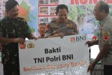 Panglima TNI Marsekal TNI Hadi Tjahjanto (Kiri) dan Kapolri Jenderal Pol Tito Karnavian (tengah) menyerahkan bantuan dana Bakti TNI, Polri dan BNI secara simbolis kepada Bupati Konawe Utara Ruksamin (kanan) di Rujab Bupati Konawe Utara, Sulawesi Tenggara, Sabtu (22/6/2019). Bantuan tersebut diberikan untuk rehabilitasi pascabanjir bagi para korban di Kabupaten Konawe Utara. ANTARA FOTO/Jojon/wsj.