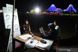 Seniman melukis wisatawan di lokasi Nusa Dua Light Festival bertema “Mountain View” di kawasan pariwisata The Nusa Dua, Badung, Bali, Minggu (23/06/2019) malam. Festival lampu dan lampion yang berlangsung sejak 30 Mei hingga 14 Juli ini akan diakhiri dengan kolaborasi bersama Bali Blues Festival (13-14 Juli 2019) yang akan menghadirkan sejumlah artis ternama di antaranya Gugun Blues Shelter ft Emmy Tobing, Endah n Rhesa, Balawan, dan Gus Teja. Antaranews Bali/Fikri Yusuf