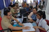 Calon peserta didik baru didampingi orang tuanya melakukan pendaftaran Penerimaan Peserta Didik Baru (PPDB) jalur zonasi serta jalur kurang mampu dan inklusi di Rumah Pintar, Denpasar, Bali, Senin (24/6/2019). Sistem pendaftaran PPDB jalur zonasi, jalur siswa kurang mampu dan inklusi tingkat SMP di Denpasar sempat mengalami gangguan sehingga menimbulkan antrean. ANTARA FOTO/Nyoman Hendra Wibowo/nym.