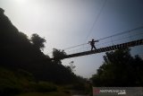 Siluet anggota Vertical Rescue Indonesia yang melakukan perawatan Jembatan Cisanggarung yang merupakan jembatan ke-75  dalam rangkaian Ekspedisi 1.000 Jembatan Gantung untuk Indonesia di Cisanggarung, Kabupaten Bandung, Jawa Barat, Senin (24/6/2019). Ekspedisi 1.000 Jembatan Gantung Untuk Indonesia yang digagas oleh Vertical Rescue Indonesia tersebut ditukukan untuk membantu kegiatan sehari-hari masyarakat, seperti sekolah, berbelanja, bekerja serta untuk membantu fasilitas sektor pariwisata di Indonesia. ANTARA JABAR/Raisan Al Farisi/agr