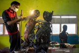 Siswa menyelesaikan pembuatan robot polisi berbahan onderdil motor bekas di SMK Karya Utama, Warung Bambu, Karawang, Jawa Barat, Senin (24/6/2019). Robot tersebut menggambarkan polisi menggendong anak kecil yang diciptakan oleh siswa jurusan teknik perawatan mekanik industri untuk hadiah pada HUT Bhayangkara ke - 73. ANTARA JABAR/M Ibnu Chazar/agr