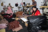 Pekerja memproduksi tas wanita di industri rumahan kawasan Wunut, Porong, Sidoarjo, Jawa Timur, Rabu (26/6/2019). Sulitnya bahan baku kulit yang diimpor dari negara China tersebut menjadi kendala utama dalam kerajinan tas wanita yang dijual dengan harga Rp18.000 - Rp40.000. Antara Jatim/Umarul Faruq/zk