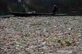 Warga menggunakan perahu untuk memilah sampah plastik di aliran Sungai Citarum, Batujajar, Kabupaten Bandung Barat, Jawa Barat, Rabu (26/6/2019). Menurut warga di kawasan tersebut volume sampah kiriman yang kerap menumpuk mulai mengalami penurunan setelah beberapa waktu lalu sempat menutupi permukaan aliran Sungai Citarum. ANTARA JABAR/Novrian Arbi/agr