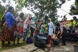 Warga dibantu anggota Polisi dan TNI mengisi air bersih gratis yang didistribusikan dari Polres Tasikmalaya Kota menggunakan mobil water cannon berisi 6.000 liter air di Desa Cijualang, Kabupaten Tasikmalaya, Jawa Barat, Kamis (27/6/2019). Sejak dua bulan lalu, daerah tersebut mengalami krisis air bersih karena dampak dari terjadinya kekeringan akibat dilanda musim kemarau, sehingga warga harus mengambil air bersih dengan jarak tempuh dua kilometer. ANTARA JABAR/Adeng Bustomi/agr