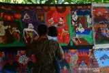 Pengunjung melihat pameran dan pertunjukan wayang beber dengan lakon Ande-ande Lumut di Mojokerto, Jawa Timur, Jumat (28/6/2019). Pagelaran wayang beber ini untuk mengenalkan nilai luhur budaya bangsa melalui wayang beber dengan lakon yang diambil dari cerita panji serta untuk melestarikan wayang tertua di Indonesia ini. Antara Jatim/Syaiful Arif/zk