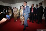 Presiden Joko Widodo (tengah) didampingi Ibu Negara Iriana Joko Widodo menyapa wartawan saat menghadiri pesta pernikahan putri pertama Gubernur Jawa Timur Khofifah Indar Parawansa, Patimasang dengan Fadil Wirawan di Surabaya, Jawa Timur, Sabtu (29/6/2019). Antara Jatim/Moch Asim/zk.