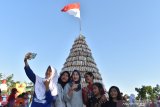 Pengunjung berada di dekat gunungan kue manco saat digelar Festival Manco 2019 di Tambakmas, Kabupaten Madiun, Jawa Timur, Sabtu (29/6/2019). Festival Manco dimaksudkan untuk mendorong perajin kue tradisional manco agar meningkatkan produksinya sekaligus menjadikan sebagai produk unggulan. Antara Jatim/Siswowidodo/zk.