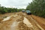 Dua mobil berupaya melintasi jalan tanah berlumpur di wilayah Kecamatan Tempunak, Kabupaten Sintang, Kalimantan Barat, Kamis (27/6/2019). Jalan kubangan berlumpur sepanjang 77 kilometer dari pedalaman menuju ibukota Kabupaten Sintang itu menjadi satu-satunya jalur yang dapat dilintasi masyarakat enam desa (Merti Jaya, Gurung Mali, Benua Kencana, Sungai Buluh, Jaya Mentari dan Riam Batu) yang bermukim di kawasan tersebut. ANTARA FOTO/HS Putra/jhwANTARA FOTO/HS PUTRA (ANTARA FOTO/HS PUTRA)