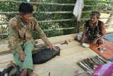 Apai Pansih (kanan) membacakan mantra dalam Bahasa Dayak Seberuang kuno saat menggelar upacara adat 'Mulai Kebuah' di rumah panggung terbuka di Dusun Lanjau, Desa Riam Batu, Kabupaten Sintang, Kalimantan Barat, Rabu (26/6/2019). Upacara adat Mulai Kebuah tersebut merupakan ritual mengembalikan roh-roh penghuni alam yang dipercaya mendiami buah-buahan yang dituai masyarakat setempat saat musim panen.  ANTARA FOTO/HS Putra/jhwANTARA FOTO/HS PUTRA (ANTARA FOTO/HS PUTRA)