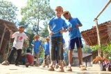 Anak-anak bermain egrang batok di sekolah alam Kampung Baca Taman Rimba (Batara) di Papring Kalipuro, Banyuwangi, Jawa Timur, Minggu (30/6/2019). Kegiatan edukasi di Kampung Batara yang digelar setiap hari minggu itu diisi dengan kegiatan permainan tradisional sebagai sarana untuk mengasah ketangkasan yang diharapkan dapat meningkatkan interaksi pergaulan antar anak dan mengurangi penggunaan perangkat elektronik seperti telepon genggam yang populer di kalangan anak-anak. ANTARA FOTO/Budi Candra Setya/wsj.