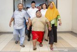 Satia Putra (7) anak penyandang obesitas dengan berat badan mencapai 101 kg didampingi Wakil Bupati Karawang Ahmad Zamaksyari (kedua kiri) bersama kedua orangtuanya berjalan menuju lokasi pemeriksaan medis di Rumah Sakit Umum Daerah (RSUD) Karawang, Karawang, Jawa Barat, Rabu (3/7/2019). Menurut pihak rumah sakit, menunggu keputusan hasil pemeriksaan dan observasi satia akan tetap ditangani oleh RSUD Karawang atau dirujuk ke Rumah Sakit Hasan Sadikin (RSHS) Bandung untuk menjalani penanganan lebih lanjut. ANTARA JABAR/M Ibnu Chazar/agr