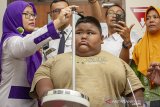 Satia Putra (7) anak penyandang obesitas dengan berat badan mencapai 101 kg dibantu petugas medis dan kedua orangtuanya mengukur tinggi badan sebelum pemeriksaan medis di Rumah Sakit Umum Daerah (RSUD) Karawang, Karawang, Jawa Barat, Rabu (3/7/2019). Menurut pihak rumah sakit, menunggu keputusan hasil pemeriksaan dan observasi satia akan tetap ditangani oleh RSUD Karawang atau dirujuk ke Rumah Sakit Hasan Sadikin (RSHS) Bandung untuk menjalani penanganan lebih lanjut. ANTARA JABAR/M Ibnu Chazar/agr