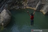 Wisatawan melompat dari atas batu di Sanghyang Heuleut yang temasuk salah satu Geopark Rajamandala, Cipatat, Kabupaten Bandung Barat, Jawa Barat, Rabu (3/7/2019). Gubernur Jawa Barat Ridwan Kamil menargetkan 49,8 juta wisatawan mengunjungi Jawa Barat sepanjang 2019, target tersebut terdiri dari 48 juta wisatawan domestik dan 1,8 juta wisatawan mancanegara. ANTARA JABAR/Raisan Al Farisi/agr