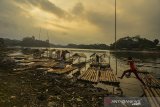 Anak-anak bermain dideretan rakit ditambatkan ditepian Danau Situ Gede yang airnya mulai surut, di Kecamatan Mangkubumi, Kota Tasikmalaya, Jawa Barat, Kamis (4/7/2019). Debit air danau objek wisata Situ Gede mulai menyusut karena dampak musim kemarau sehingga berdampak pada sepinya kunjungan wisatawan. ANTARA JABAR/agr