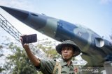 Seorang warga berfoto di depan monumen pesawat F5 Tiger usai diresmikan di Taman Lalu Lintas Ade Irma Suryani Nasution, Bandung, Jawa Barat, Jumat (5/7/2019). Monumen pesawat jet tempur F5 Tiger tersebut ditujukan untuk mengabadikan sejarah dirgantara Indonesia, serta memberikan edukasi kepada generasi penerus bangsa yang mengunjungi Taman Lalu Lintas tersebut. ANTARA JABAR/Raisan Al Farisi/agr