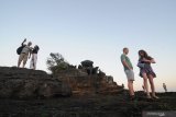 Wisatawan asing menikmati matahari terbenam di kawasan Wisata Pura Tanah Lot, Tabanan, Bali, Jumat (5/7/2019). Destinasi wisata tersebut selalu ramai pengunjung baik wisatawan asing maupun domestik terutama saat musim libur. Antara Jatim/Saiful Bahri/zk.