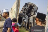 Warga melihat gerbong kereta bekas yang hangus terbakar di Area penyimpanan di Stasiun Purwakarta, Purwakarta, Jawa Barat, Sabtu (6/7/2019). Kebakaran kereta bekas yang terjadi pada sabtu (6/7/2019) dini hari itu diperkirakan menghanguskan 12 gerbong kereta bekas, sementara itu penyebab kejadian tersebut masih dalam penyelidikan lebih lanjut. ANTARA JABAR/M Ibnu Chazar/agr