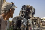 Warga melihat gerbong kereta bekas yang hangus terbakar di Area penyimpanan di Stasiun Purwakarta, Purwakarta, Jawa Barat, Sabtu (6/7/2019). Kebakaran kereta bekas yang terjadi pada sabtu (6/7/2019) dini hari itu diperkirakan menghanguskan 12 gerbong kereta bekas, sementara itu penyebab kejadian tersebut masih dalam penyelidikan lebih lanjut. ANTARA JABAR/M Ibnu Chazar/agr