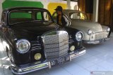 Pengunjung melihat koleksi mobil kuno yang dipajang di Museum Kampung Cak Soen, Ngawi, Jawa Timur, Sabtu (6/7/2019). Museum mobil kuno yang didirikan di tengah perkampungan tersebut ramai dikunjungi wisatawan terutama saat  liburan sekolah. Antara Jatim/Ari Bowo Sucipto/zk.