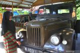 Pengunjung melihat koleksi mobil kuno yang dipajang di Museum Kampung Cak Soen, Ngawi, Jawa Timur, Sabtu (6/7/2019). Museum mobil kuno yang didirikan di tengah perkampungan tersebut ramai dikunjungi wisatawan terutama saat  liburan sekolah. Antara Jatim/Ari Bowo Sucipto/zk.