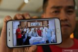 Seorang WNI menunjukan foto Kepala Pusat Data, Informasi dan Humas Badan Nasional Penanggulanhan Bencana (BNPB) Sutopo Purwo Nugroho ketika dirawat di Modern Hospital Guangzhou Guangzhou, Guangdong, China, Minggu (7/7/2019). Sutopo meninggal di rumah sakit tersebut karena sakit kanker paru-paru stadium empat sekitar pukul 02:00 dini hari waktu setempat dan rencananya pada pukul 15:45 waktu setempat jenazahnya akan diberangkatan ke Tanah Air dengan pesawat Garuda Indonesia. Antara Jatim/Zabur Karuru