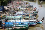 Sebuah perahu melintas di samping puluhan perahu nelayan yang bersandar di sungai kawasan Cemandi, Sedati, Sidoarjo, Jawa Timur, Senin (8/7/2019). Dampak gelombang tinggi yang mencapai lebih dari tiga meter menerjang sepanjang laut selatan Pulau Jawa sepekan terakhir, memaksa nelayan tradisional di pesisir tersebut tidak melaut. Antara Jatim/Umarul Faruq/zk