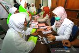 Jamaah calon haji (JCH) yang tergabung dalam kelompok terbang (kloter) I Embarkasi Banjarmasin melakukan pemeriksaan kesehatan sebelum memasuki Asrama haji Embarkasi Banjarmasin, Banjarbaru, Kalimantan Selatan, Senin (8/7/2019).Sebanyak 320 JCH dari Hulu Sungai Selatan, dan Banjarmasin yang tergabung dalam keloter I Kalsel mulai datang dan masuk asrama haji Embarkasi Banjarmasin dan akan diberangkatkan menuju Madinah Selasa (9/7/2019) melalui Bandara Syamsuddin Noor Banjarmasin.Foto Antaranews Kalsel/Bayu Pratama S.