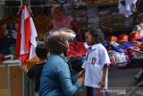 Calon pembeli memakaikan seragam sekolah ke anaknya di pasar senggol Bhayangkara Jombang, Jawa Timur, Senin (8/7/2019). Penjual mengaku tidak terkena imbas adanya program seragam gratis, bahkan penjualan seragam sekolah menjelang awal masuk sekolah pekan depan mengalami peningkatan cukup tajam dibandingkan hari biasa yang dijual berkisar antara Rp65 ribu-Rp110 ribu per setel untuk sekolah dasar hingga SMA.  Antara Jatim/Syaiful Arif/zk