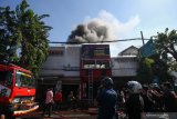 Petugas memadamkan bangunan yang terbakar di Jalan Bubutan, Surabaya, Jawa Timur, Selasa (9/7/2019). Sebanyak 15 kendaraan pemadam kebakaran dikerahkan untuk memadamkan kebakaran yang melanda tiga tempat usaha yaitu dealer sepeda motor Yamaha serta bengkel dan penjualan sepeda angin. Antara Jatim/Didik Suhartono/ZK