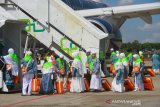 Sejumlah jamaah calon haji asal Hulu Sungai Selatan dan Banjarmasin berjalan memasuki pesawat saat keberangkatan kloter pertama di Bandara Syamsuddin Noor, Banjarbaru, Kalimantan Selatan, Selasa (9/7/2019).Jamaah calon haji (JCH) yang tergabung pada kloter pertama dari Kalsel tersebut memberangkatkan sebanyak 320 JCH menuju Tanah suci.Foto Antaranews Kalsel/Bayu Pratama S.