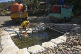 Warga menyedot air dari kolam penampungan sementara di dalam kawasan aliran Sungai Kaligoro yang mulai mengering di Sudimoro, Pacitan, Jawa Timur, Selasa (9/7/2019). Kekeringan yang melanda sebagian besar wilayah tersebut memaksa warga menggunakan resapan air sungai yang ada untuk memenuhi kebutuhan konsumsi, MCK (mandi cuci kakus) maupun kebutuhan industri rumah tangga lainnya. Antara Jatim/Destyan Sujarwoko/zk.