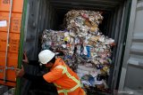 Petugas menunjukkan kertas bekas (waste paper) impor yang dikirim dari Australia di lapangan penumpukkan kontainer di PT Terminal Petikemas Surabaya (TPS) di Surabaya, Jawa Timur, Selasa (9/7/2019). Kantor Pengawasan dan Pelayanan Bea dan Cukai (KPPBC) Tipe Madya Pabean (TMP) Tanjung Perak Surabaya mengamankan delapan kontainer yang berisi 282 bal dengan berat total 210,34 ton kertas bekas (waste paper) yang terkontaminasi berbagai sampah rumah tangga dan terkontaminasi limbah Bahan Berbahaya dan Beracun (B3). Antara Jatim/Didik Suhartono/ZK