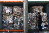 Petugas menunjukkan kertas bekas (waste paper) impor yang dikirim dari Australia di lapangan penumpukkan kontainer di PT Terminal Petikemas Surabaya (TPS) di Surabaya, Jawa Timur, Selasa (9/7/2019). Kantor Pengawasan dan Pelayanan Bea dan Cukai (KPPBC) Tipe Madya Pabean (TMP) Tanjung Perak Surabaya mengamankan delapan kontainer yang berisi 282 bal dengan berat total 210,34 ton kertas bekas (waste paper) yang terkontaminasi berbagai sampah rumah tangga dan terkontaminasi limbah Bahan Berbahaya dan Beracun (B3).  Antara Jatim/Didik Suhartono/ZK