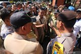 Polisi dan Satpol PP menenangkan sejumlah kepala desa yang berunjuk rasa menuntut diselenggarakannya pemilihan kepala desa (pilkades) serentak di kantor Pemkab Kediri, Jawa Timur, Rabu (10/7/2019). Sedikitnya 200 kepala desa berunjuk rasa menuntut segera diselenggarakannya pilkades serentak di 250 desa agar tidak terjadi kekosongan jabatan yang pada akhirnya hanya akan diisi oleh pejabat sementara dari unsur aparatur sipil negara (PNS) yang tidak sesuai dengan pilihan masyarakat. Antara Jatim/Prasetia Fauzani/zk.