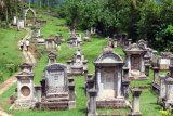 Pengunjung berada di kawasan cagar budaya makam Belanda (Kerkhof), di Sawahlunto, Sumatera Barat, Rabu (10/7/2019). Makam Belanda sebanyak 94 buah tersebut merupakan salah satu destinasi wisata sejarah di kota tambang itu. ANTARA FOTO/Iggoy el Fitra/nym.