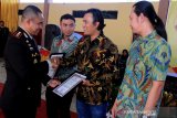 Kapolres Aceh Barat AKBP Raden Bobby Aria Prakasa (kiri) menyerahkan piagam penghargaan kepada lembaga penggiat lingkungan yang terdiri dari Forum Konservasi Leuser (FKL), WildLife Conservation Society (WCS) dan Yayasan Hutan, Alam dan Lingkungan Aceh (HAkA) saat syukuran HUT ke-73 Bhayakara di Mapolsek Meureubo, Aceh Barat, Aceh, Rabu (10/7/2019). Penyerahan penghargaan tersebut sebagai bentuk terima kasih dengan pihak terkait yang telah membantu dan mendukung tugas kepolisian dalam memberantas tindak kejahatan lingkungan. (Antara Aceh/Syifa Yulinna)