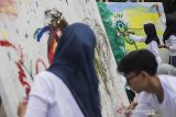 Pelajar membuat lukisan saat kolaborasi pertunjukan seni Doa untuk Bumi bersama maestro Tisna Sanjaya di River spot Cikapundung, Bandung, Jawa Barat, Kamis (11/7/2019). Kolaborasi pertunjukan seni Doa untuk Bumi ini merupakan kegiatan berbagi energi dan spirit melalui proses penciptaan karya seni untuk mendoakan kedamaian bumi, Indonesia dan dunia. ANTARA JABAR/M Agung Rajasa/agr